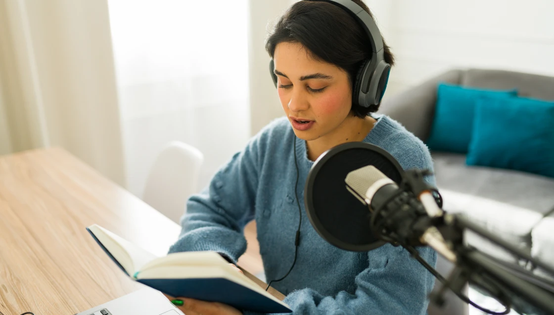Person reading aloud into microphone
