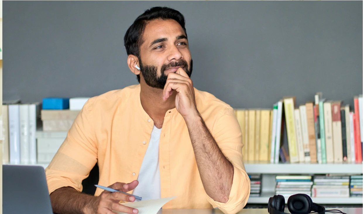 Man thinking with pen in hand