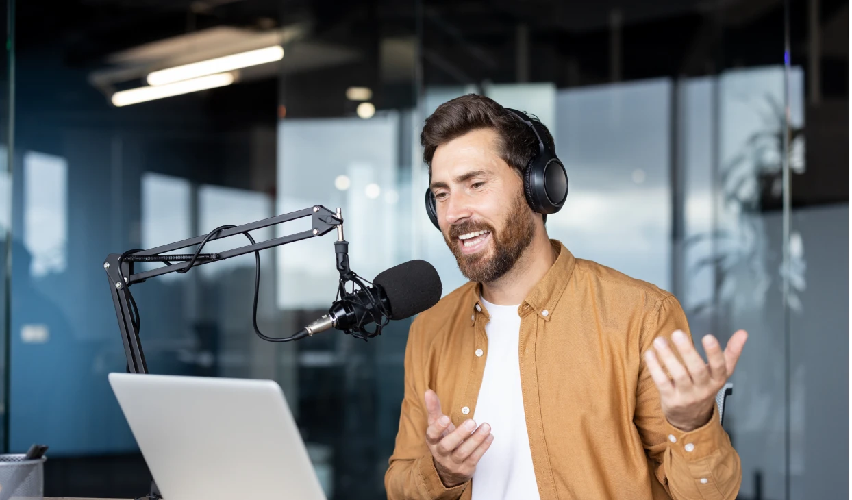 Podcaster speaking into microphone with headphones