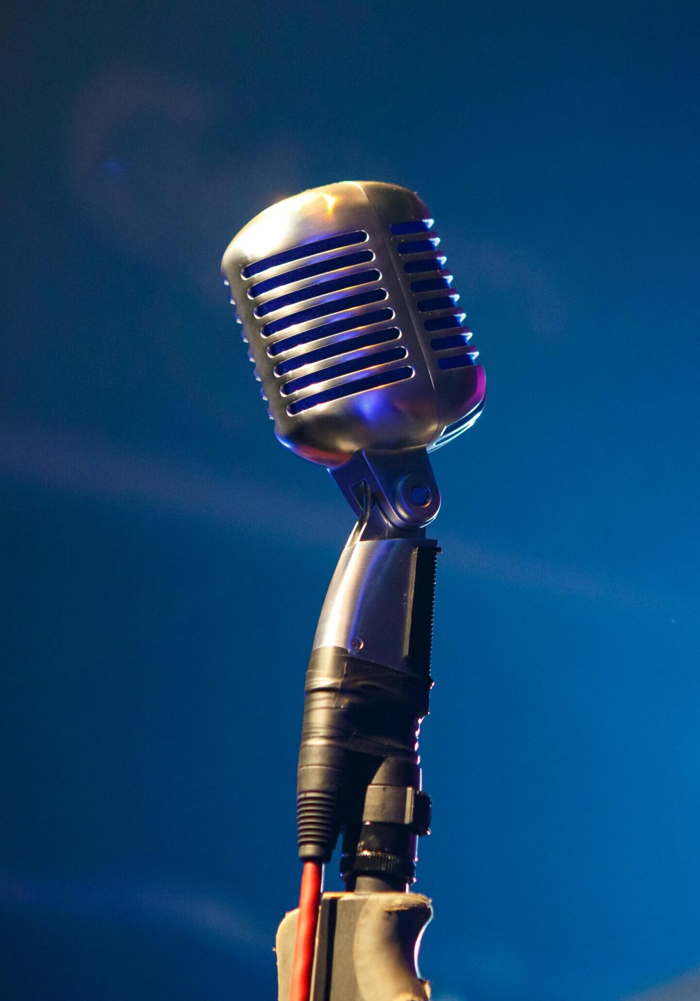 Vintage-style microphone illuminated by blue light.